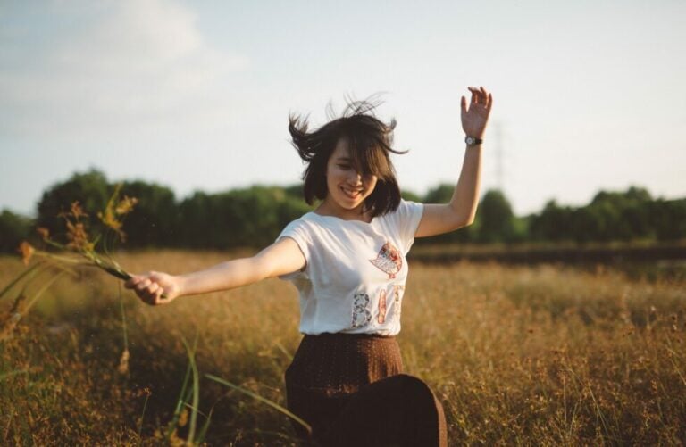 girl holding flowers doing a twirl in a field