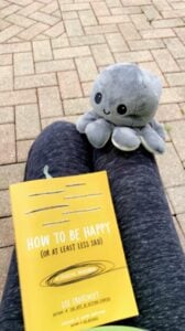 book and stuffed animal on the lap of someone