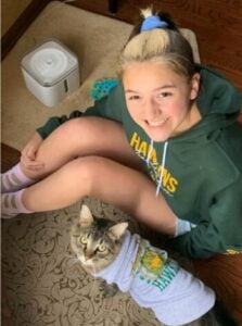 a young girl and her cat wearing matching sweatshirts