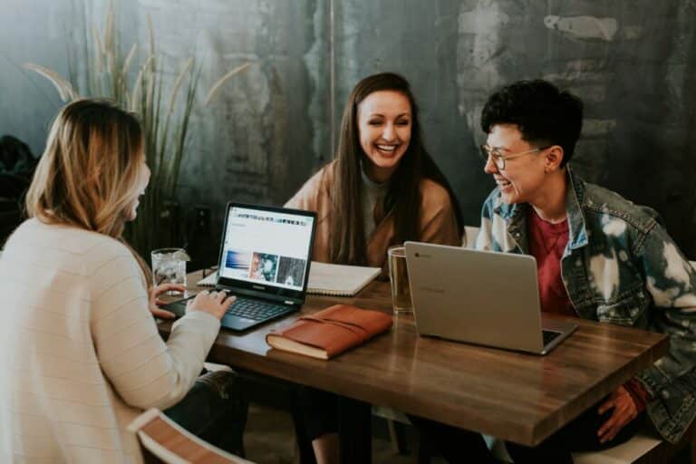 people working at a table with their computers