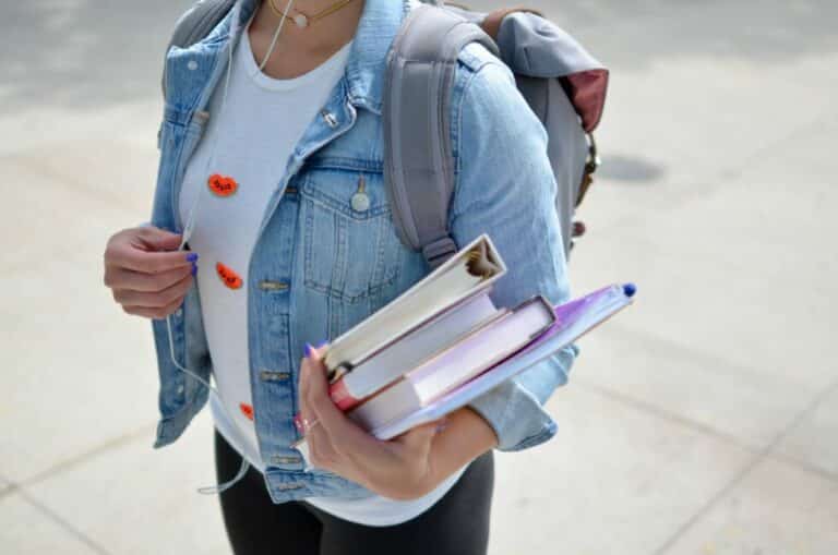 person carrying books listening to headphones