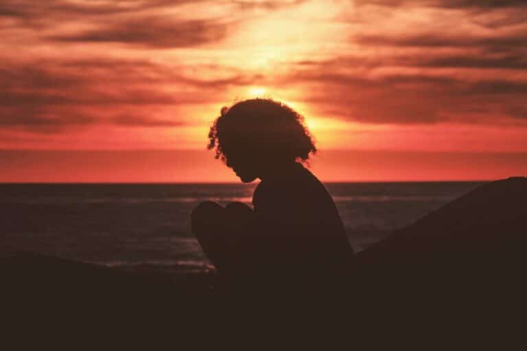 kid kneeling with sunset behind
