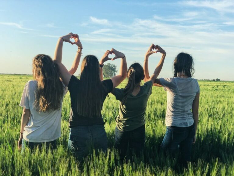 group of youth holding up their hands and making hearts with their fingers
